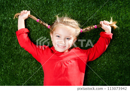 little girl smiling on a green lawn 113073942