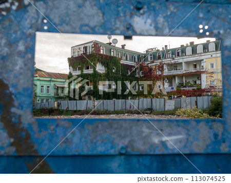 Streets of the southern city. Ivy on the building. Resort place. Streets of Batumi. House overgrown with greenery. Nature and architecture. The concept of the struggle between nature and the city Streets of the southern city. Ivy on the building. Resort place. Streets of Batumi. House overgrown with greenery. Nature and architecture. The concept of the struggle between nature and the city 113074525