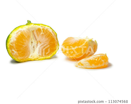 Unripe tangerine. Peeling a tangerine. Green fruit on a white background. Sour ingredient. Citrus isolate. Sliced green mandarin. 113074568