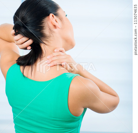 young brunette woman with a pain in the neck 113074635