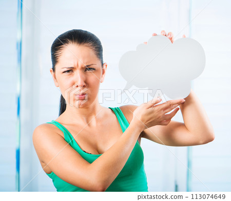 sulky young brunette woman holding a white cloud for text 113074649