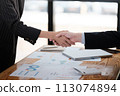 Business people in office suits standing and shaking hands, close-up. Business communication concept. Handshake and marketing 113074894