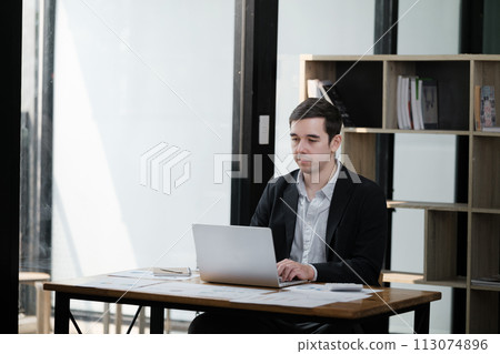 Handsome well dressed businessman working at his office, businessman working on a project Handsome well dressed businessman working at his office, businessman working on a project 113074896