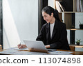 Portrait of Young Successful Asian Businesswoman Sitting at Desk Working on Laptop Computer in Office. Ambitious Corporate Manager Plan Investment Strategy for e-Commerce Project. 113074898