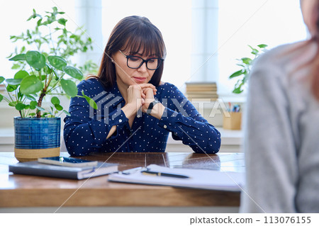 Mature sad woman in therapy session with mental professional Mature sad woman in therapy session with mental professional 113076155