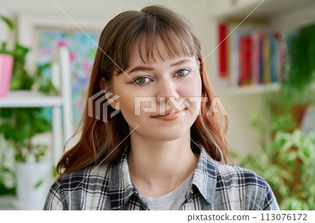 Portrait of smiling female teenager looking at camera in home Portrait of smiling female teenager looking at camera in home 113076172