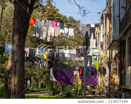Colorful street. Yard with stretched clotheslines. Clothes are dried in the yard. Quiet backyard of Georgia. 113077140