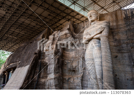 The standing image depicts an unusual mudra is said to be the finest of the series at Gal Vihara in ancient city of Polonnaruwa, Sri Lanka. The standing image depicts an unusual mudra is said to be the finest of the series at Gal Vihara in ancient city of Polonnaruwa, Sri Lanka. 113078363