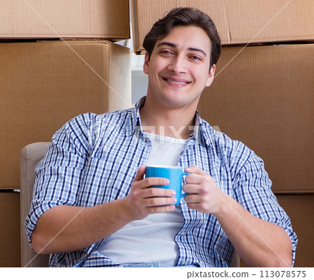 Young man moving in to new house with boxes Young man moving in to new house with boxes 113078575