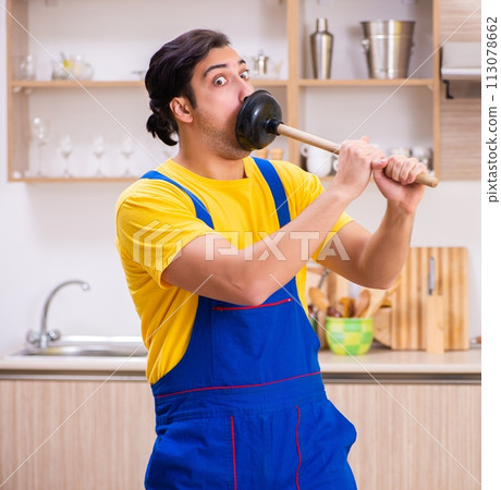 Young male contractor repairing tap at home 113078662