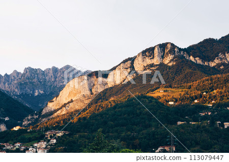 Beautiful landscape of the layered misty hazy Italian Alps mountain range during evening. Lombardy, Italy Beautiful landscape of the layered misty hazy Italian Alps mountain range during evening. Lombardy, Italy 113079447