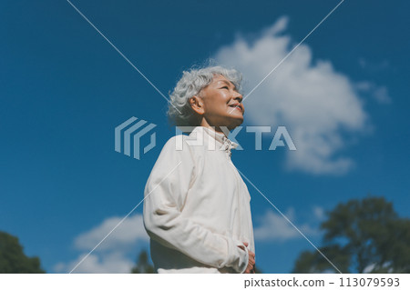 Senior woman in a jersey looking up at the sky Senior woman in a jersey looking up at the sky 113079593