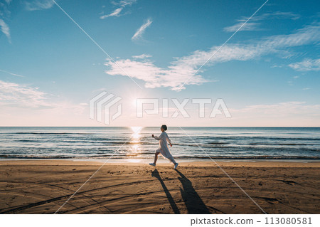 Sun setting over the sea and silhouette of a woman 113080581