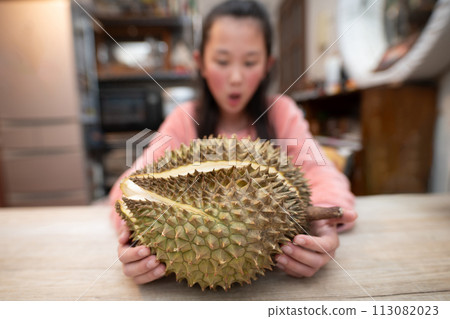 A child is happy holding a large durian A child is happy holding a large durian 113082023