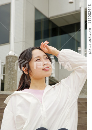 A woman taking a break while jogging A woman taking a break while jogging 113082448