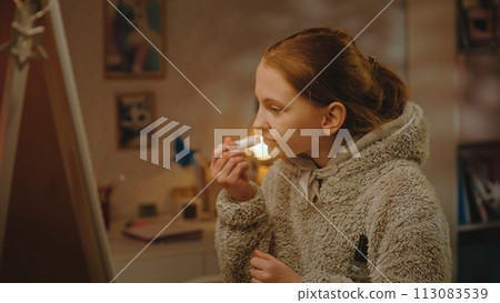 Young girl does makeup standing and taking picture in the mirror Young girl does makeup standing and taking picture in the mirror 113083539