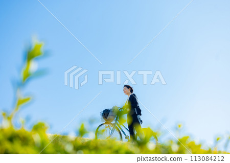 Middle-aged woman commuting to work on a bicycle 113084212