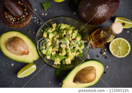Chopped avocado in glass bowl and avocado Halves 113085105