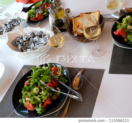 Table of a french restaurant with mixed lettuce salad and flatware. High quality photo 113086223