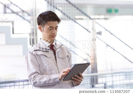 Men in work clothes middle tablet 113087207