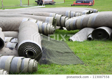 Old artificial lawn twisted into rolls Old artificial lawn twisted into rolls 113087558