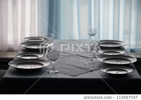 Table in the restaurant with empty plates and glass goblets.Empty table in the restaurant 113087597