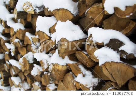 Firewood neatly folded covered with snow for the stove and fireplace Firewood neatly folded covered with snow for the stove and fireplace 113087768