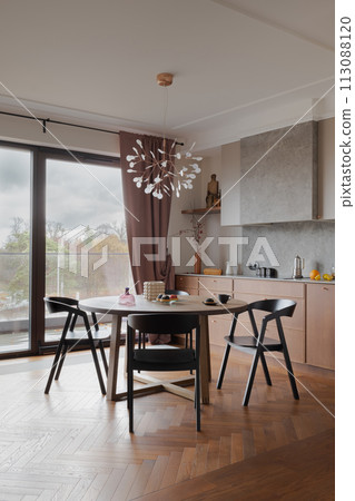 Building with table, chairs, large window, hardwood flooring 113088120