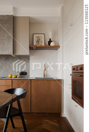 Kitchen with wooden cabinetry, table, chairs, and hardwood flooring 113088125