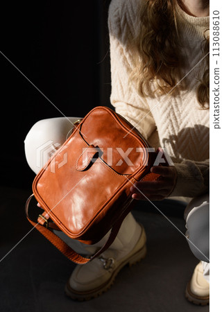beautiful curly blond hair woman posing squatting with a small brown near grey wall beautiful curly blond hair woman posing squatting with a small brown near grey wall 113088610