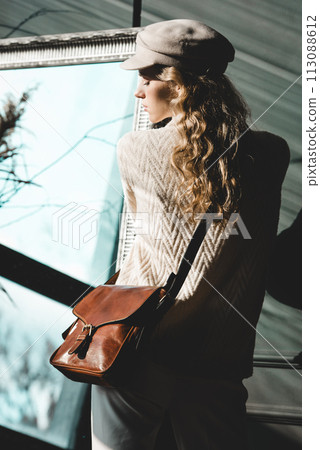 beautiful curly blond hair woman posing with a small brown near grey wall beautiful curly blond hair woman posing with a small brown near grey wall 113088612