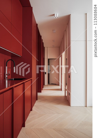 Hallway with red cabinets, a sink, and brown hardwood flooring 113088684