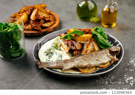 Portion of grilled fish with potato and sauce Portion of grilled fish with potato and sauce 113090364