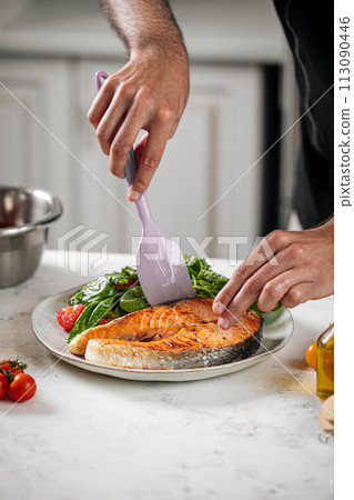 Portion of grilled salmon steak with vegetables 113090446