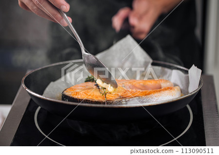 Man cooking salmon steak roasting on parchment 113090511