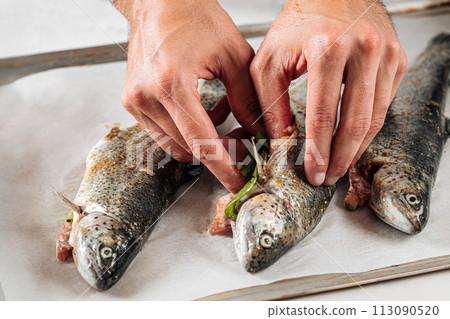 Chef stuffs fish for cooking Chef stuffs fish for cooking 113090520