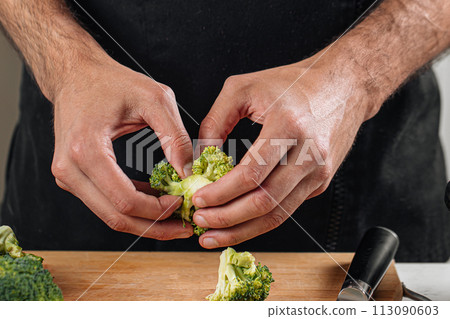 Chef separating broccoli preparing meal Chef separating broccoli preparing meal 113090603