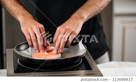 Man cooking salmon steak roasting on parchment 113090617