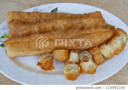 Top view of cakoi or Youtiao on white plate. Asian food concept Top view of cakoi or Youtiao on white plate. Asian food concept 113091193