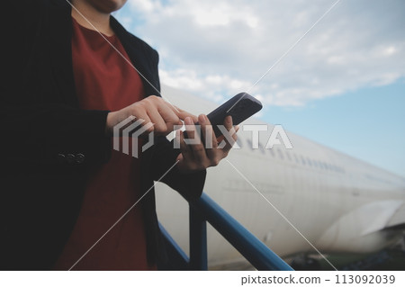 Young asian woman in international airport, using mobile smartphone and checking flight at the flight information board Young asian woman in international airport, using mobile smartphone and checking flight at the flight information board 113092039