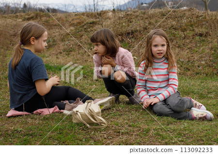 Children sitting on grass in the countryside Children sitting on grass in the countryside 113092233