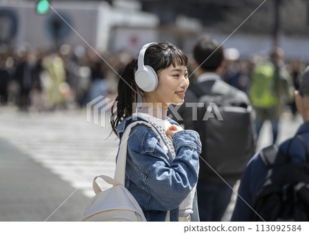 戴著耳機微笑的年輕女子 113092584