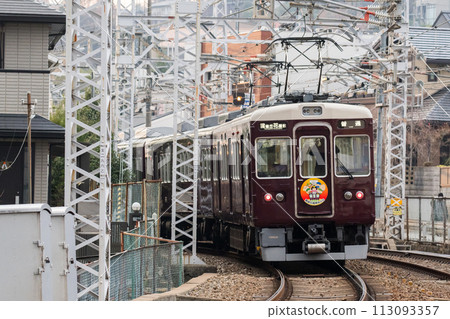 [Hankyu Takarazuka Line] A train passing through a shopping street 113093357