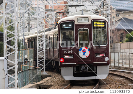 [Hankyu Takarazuka Line] A train passing through a shopping street 113093370