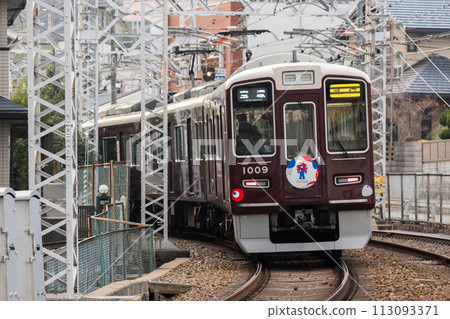 [Hankyu Takarazuka Line] A train passing through a shopping street 113093371
