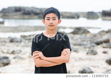 A man holding his arms on the beach 113093710