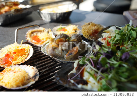 various types of clams are grilled on a grill and then dipped in seasoning and eaten. various types of clams are grilled on a grill and then dipped in seasoning and eaten. 113093938
