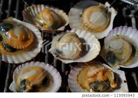 various types of clams are grilled on a grill and then dipped in seasoning and eaten. 113093943