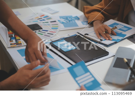 Close up ux developer and ui designer use augmented reality brainstorming about mobile app interface wireframe design on desk at modern office.Creative digital development agency 113095469