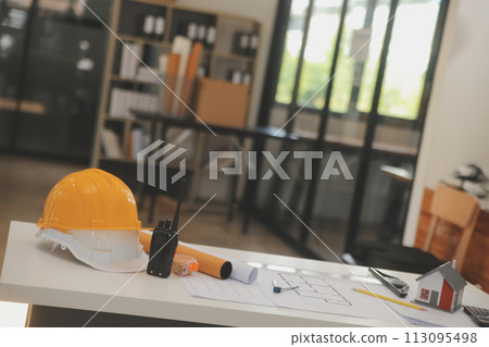 Male and Female Industrial Engineers in Hard Hats Discuss New Project while Using Laptop. They Make Showing Gestures.They Work in a Heavy Industry Manufacturing Factory. 113095498
